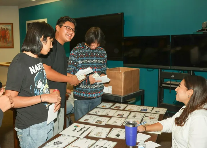 Kay Medicine Bull assists students at the $pending Frenzy at Lame Deer High School on Sept. 15. / Photo courtesy of Tommy Rob